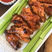 celery and buffalo chicken wings on a white platter