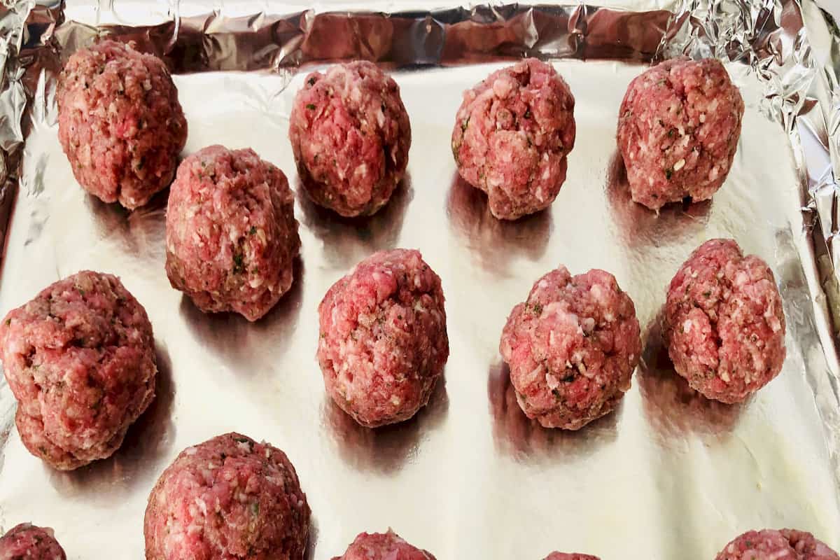 meatballs on aluminum foil lined baking sheet.