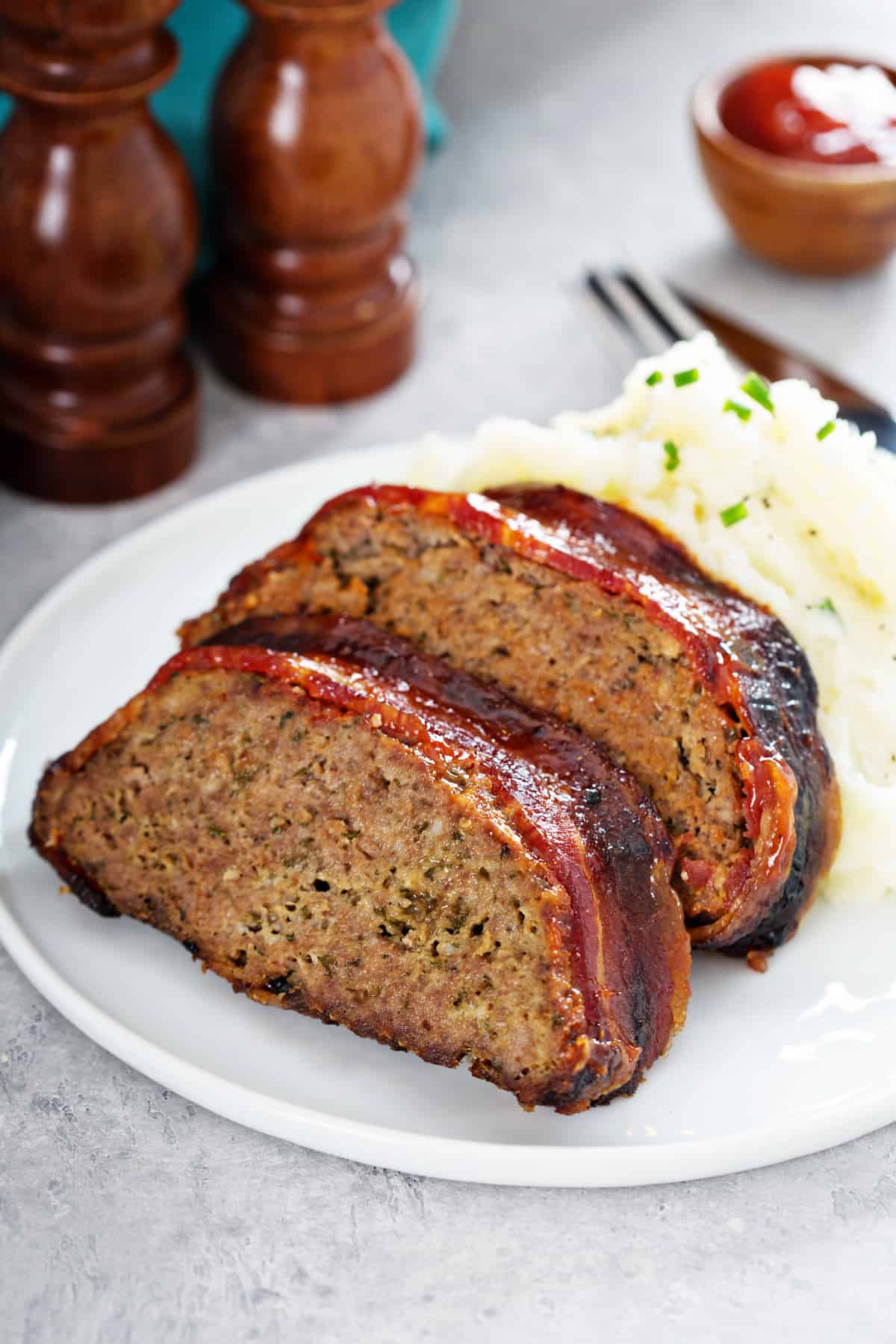 air fryer turkey meatloaf wrapped in bacon with mashed potatoes.