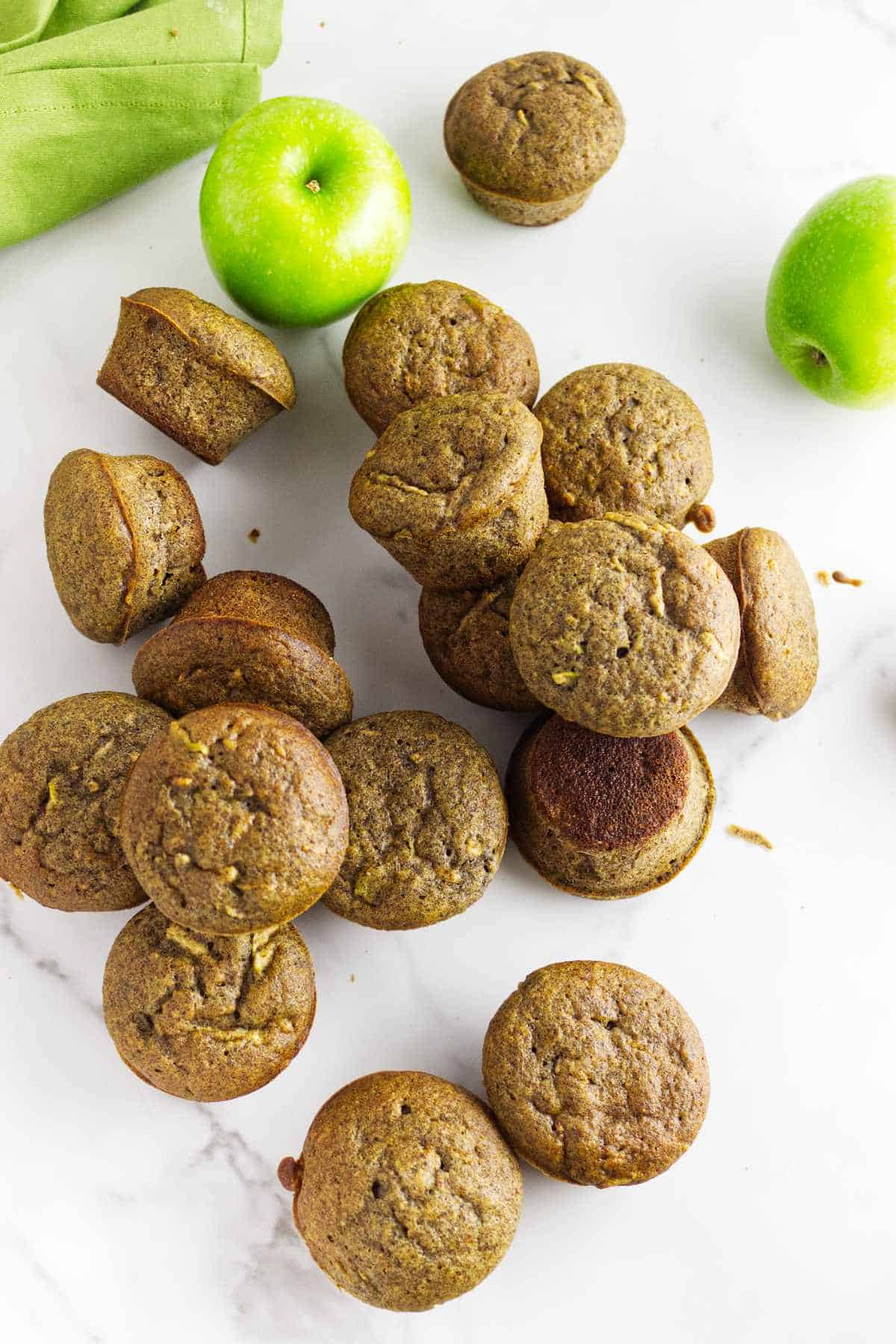 apple flaxseed muffins with Granny Smith apples on a white background.