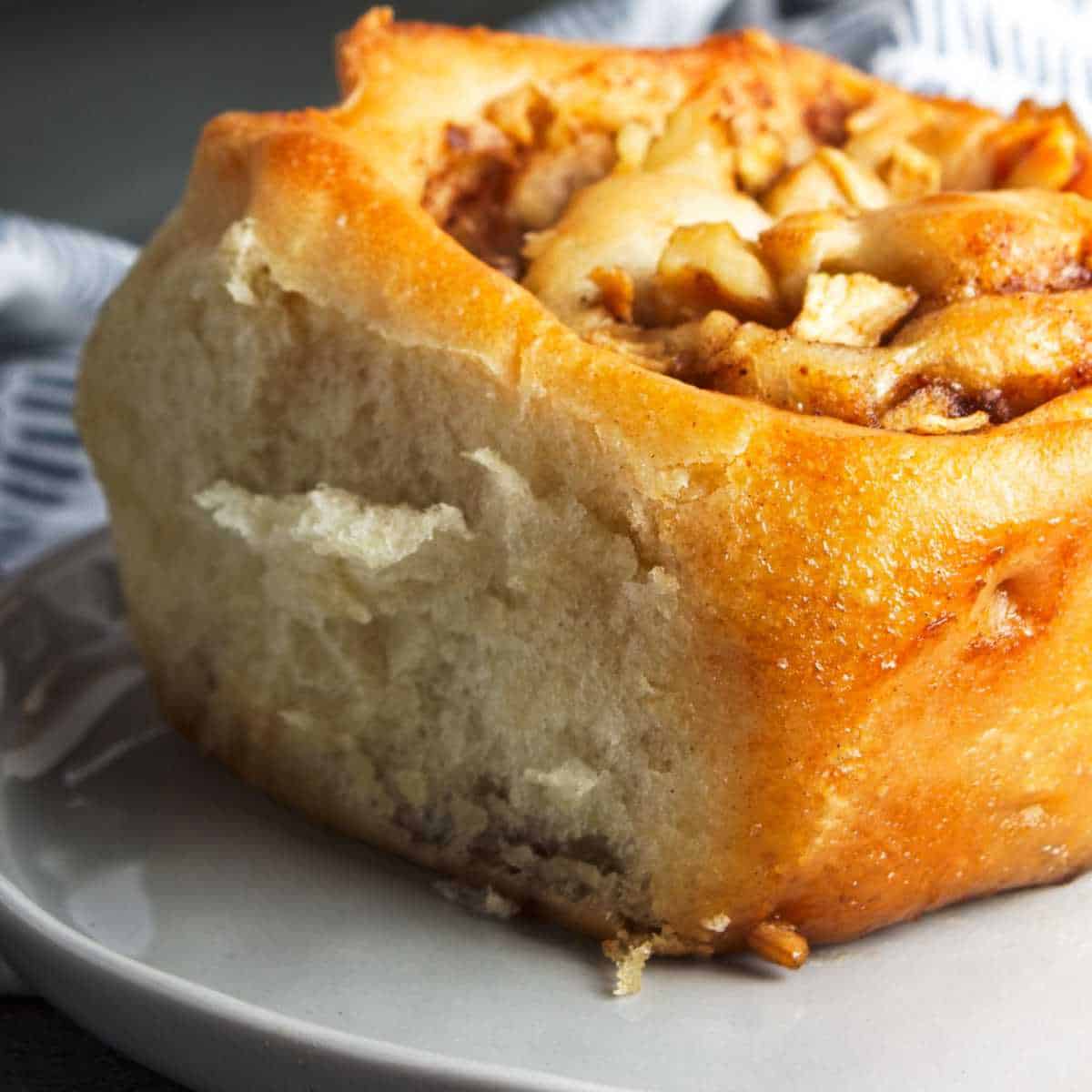 one cinnamon apple rolls on a serving plate.