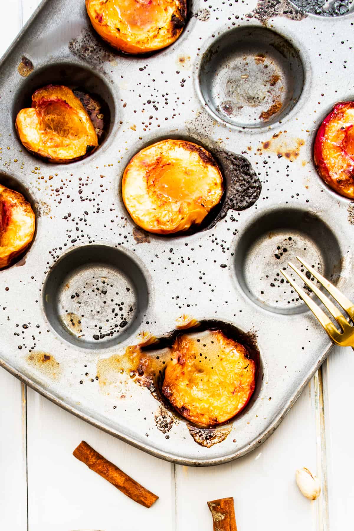 Roasted  stone fruit in a muffin tin.