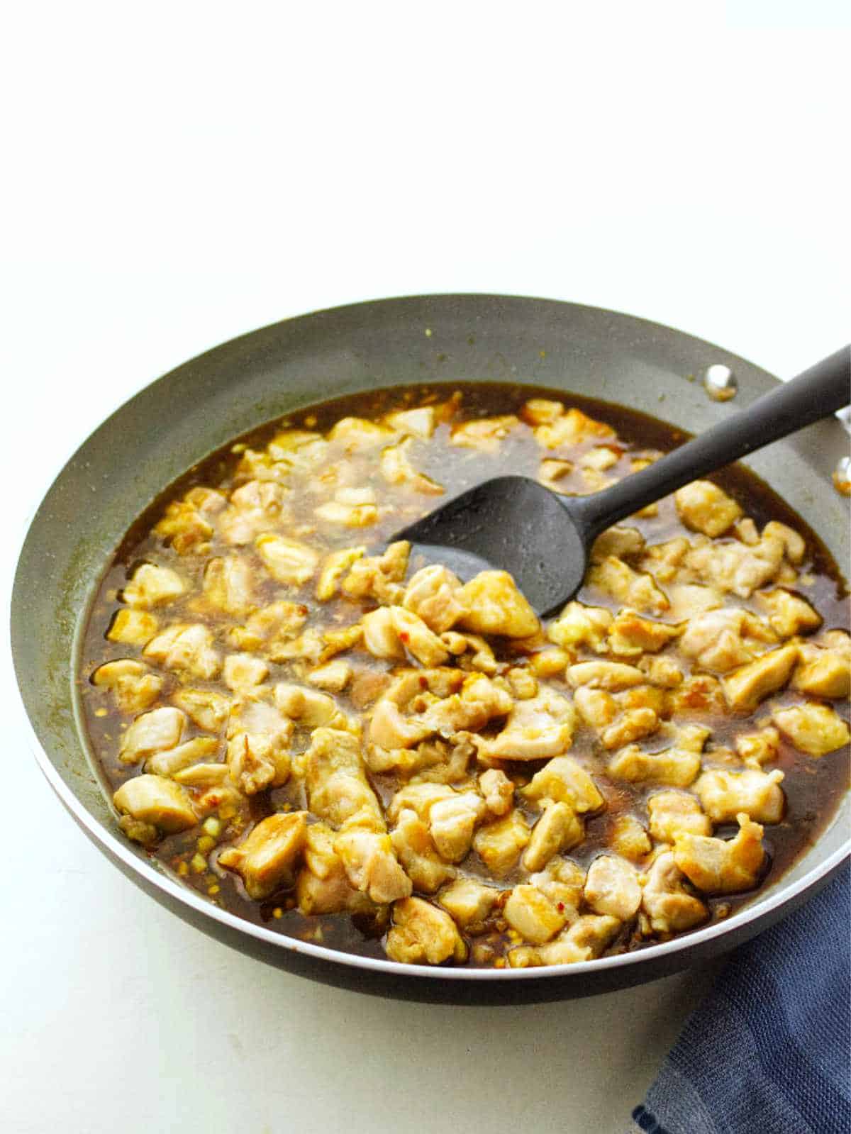 Chicken simmering in bourbon chicken sauce.