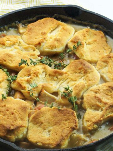 cast iron chicken pot pie with biscuits on top.