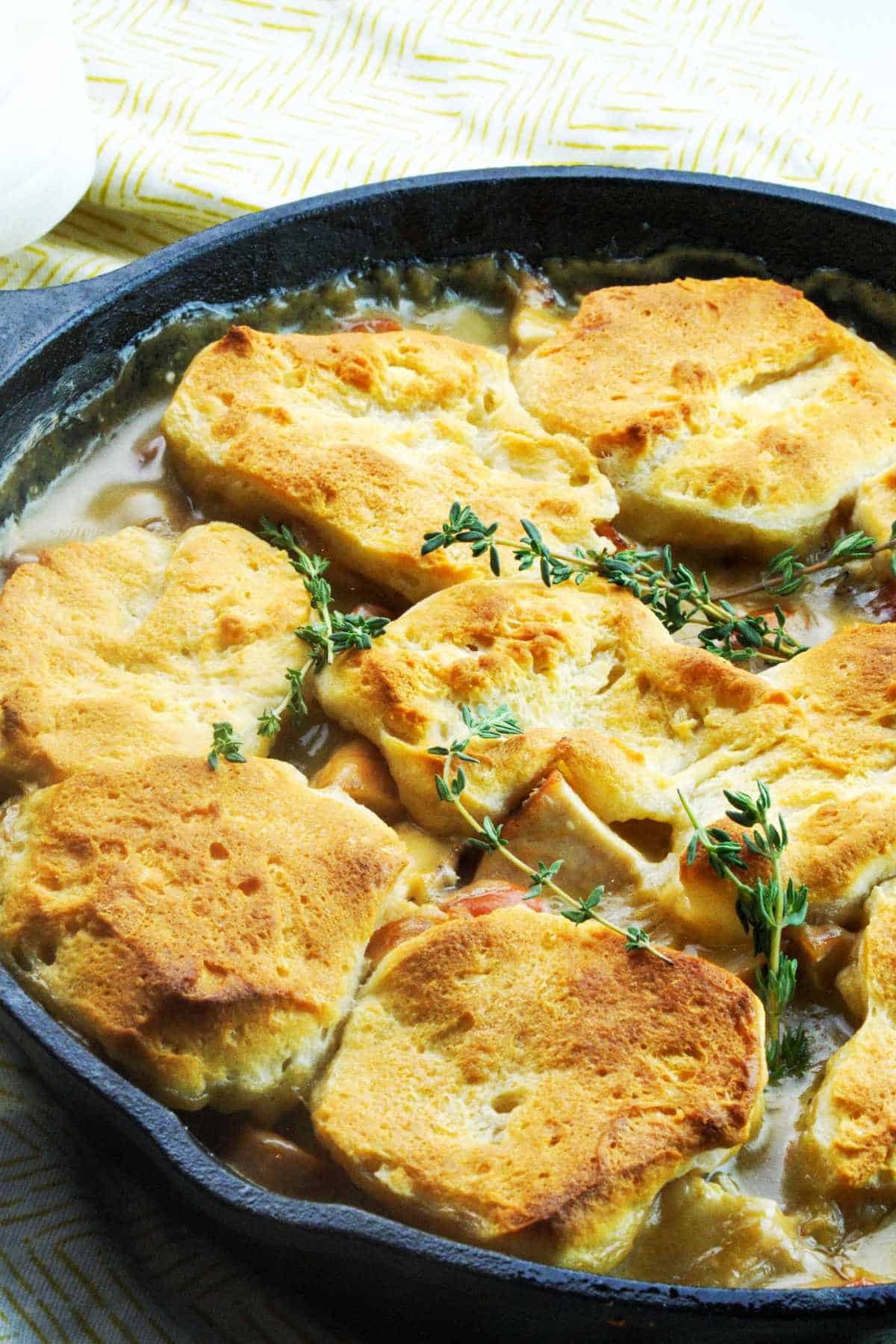 cast iron chicken pot pie with biscuits on top.