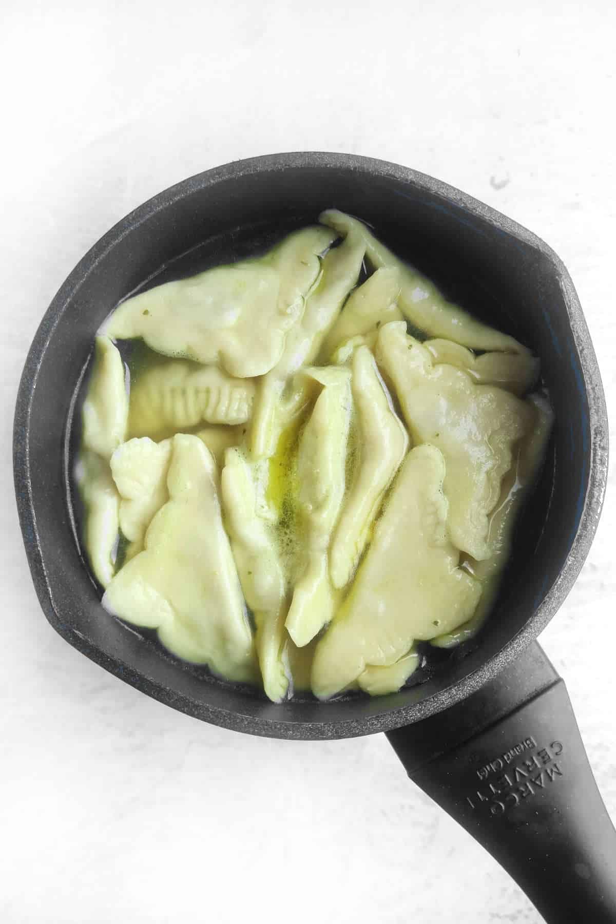 kreplach dumplings simmering in broth.