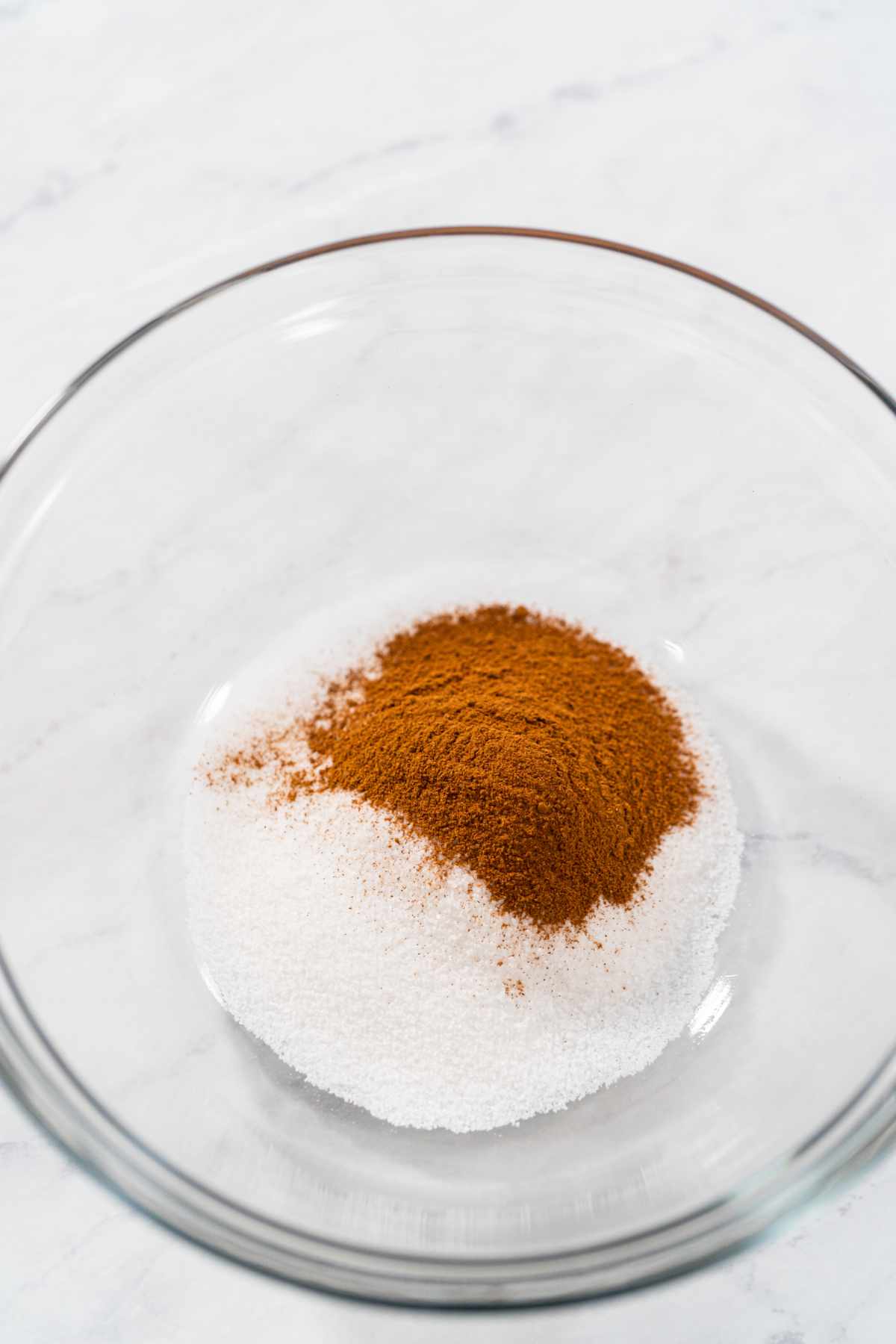 white sugar added to mixing bowl with ground cinnamon.