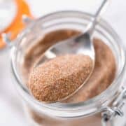 Cinnamon sugar in a glass mason jar on the marble surface.