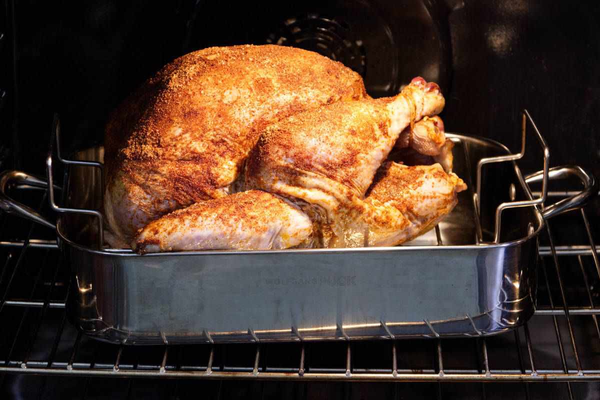 turkey in a roasting pan in an oven.