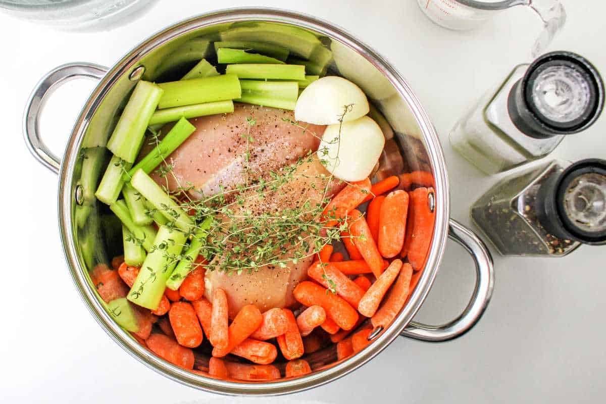 vegetables and seasonings in pot with breast chicken meat.