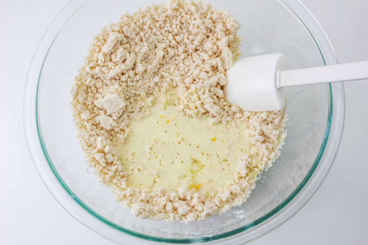 milk and egg added to flour mixture in a bowl.