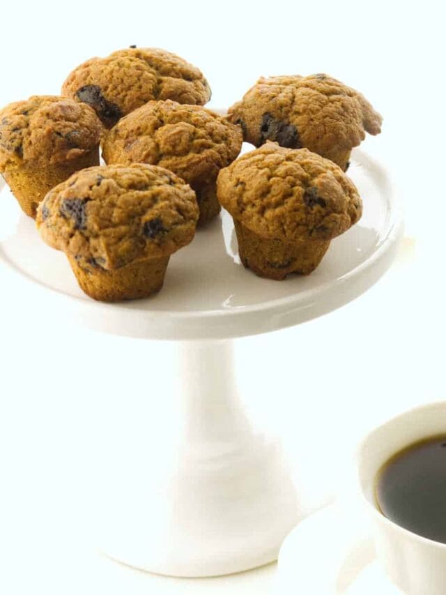 cake plate with mini muffins and a cup of steaming coffee. Halloween party food idea.