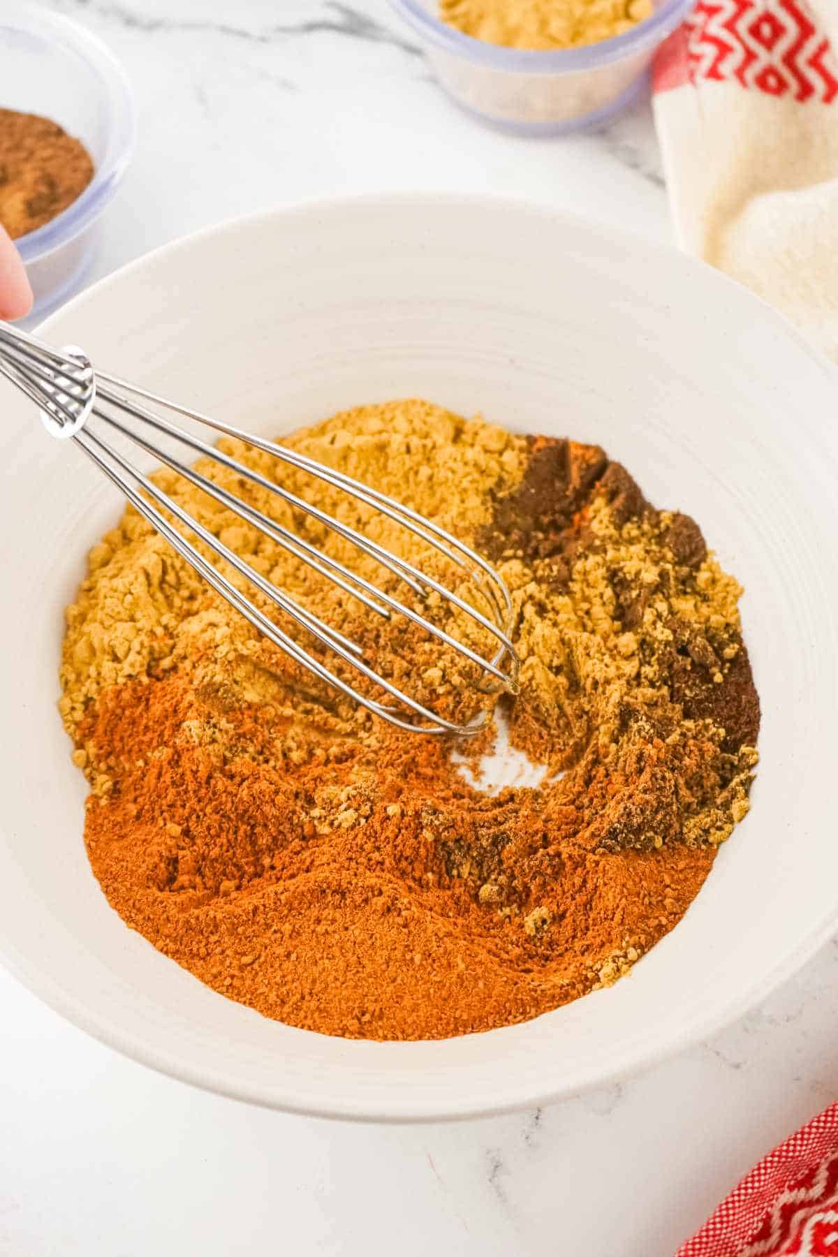 whisk blending spices in a bowl.