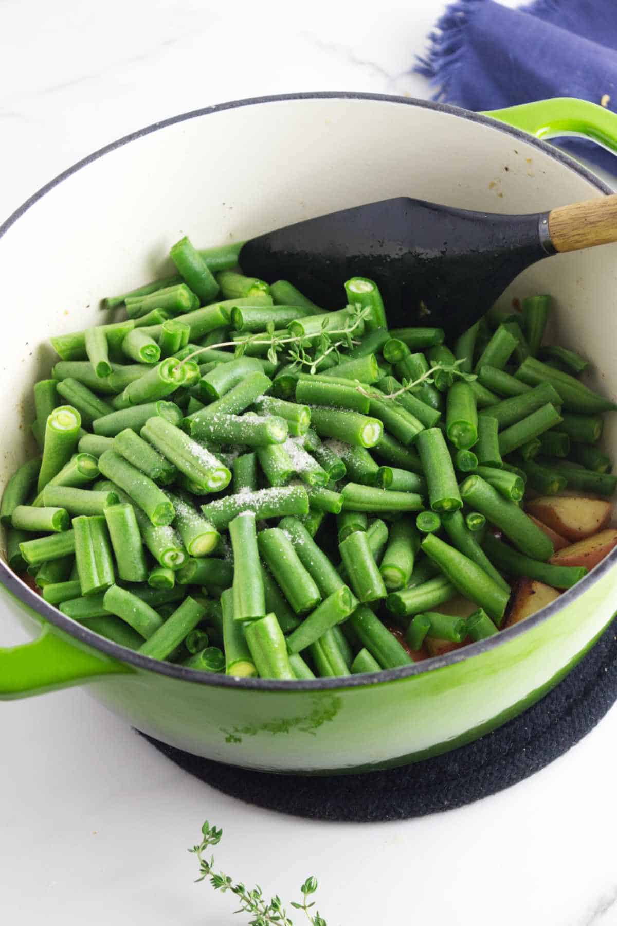 seasoning added to a dutch oven kettle of vegetables.