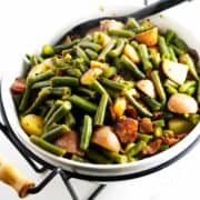 serving bowl with green beans, bacon, and potatoes.