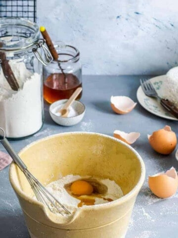 yellow mixing bowl, eggs, and whisk