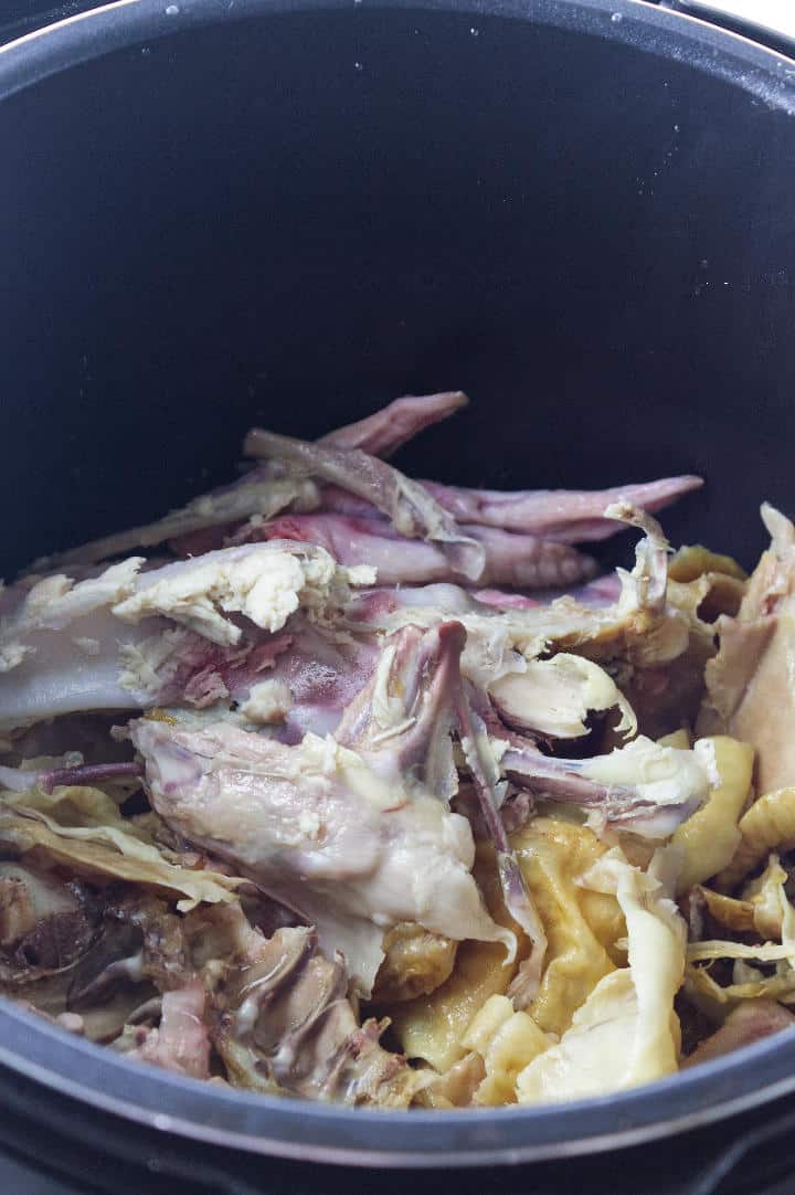 raw chicken and chicken carcass bones in an instant pot for broth.