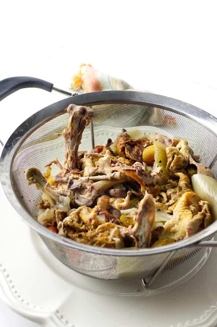 colander with stewed chicken bones & vegetables.