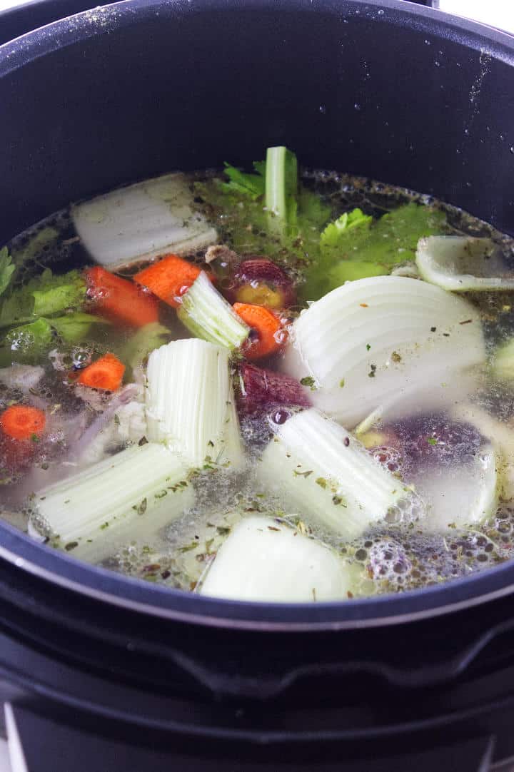 fresh vegetables, water, and raw chicken trimmings in an instant pot.