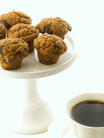 cake plate with mini muffins and a cup of steaming coffee