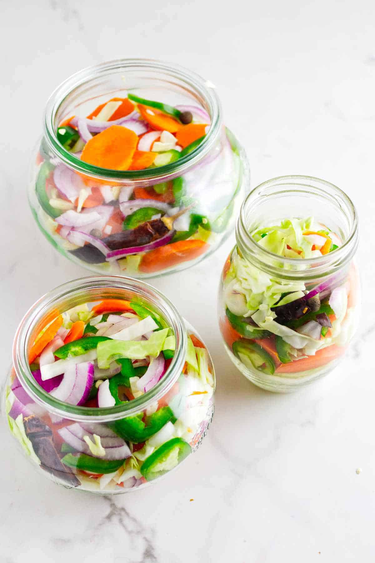 canning jars filled with cut vegetable mixture.