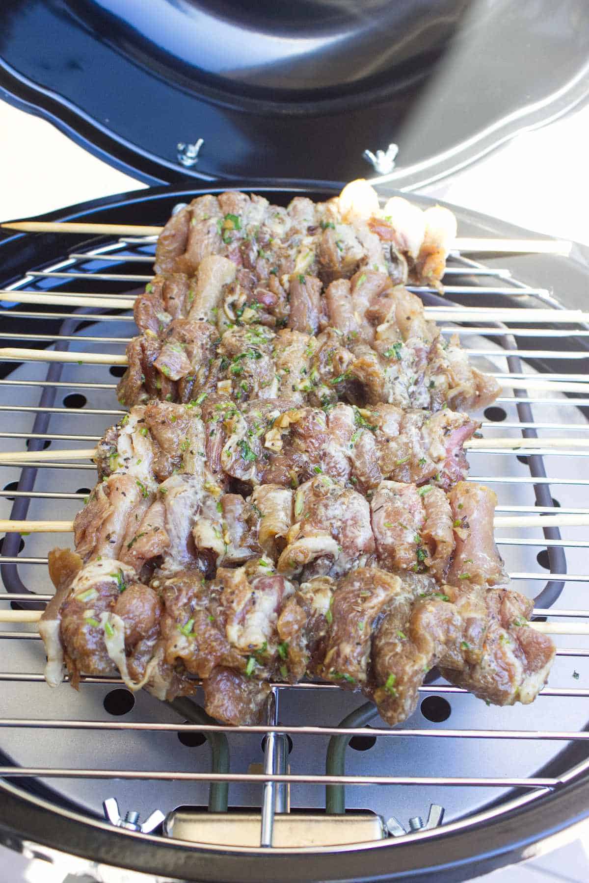 Thai pork skewers grilling on an electric grill.