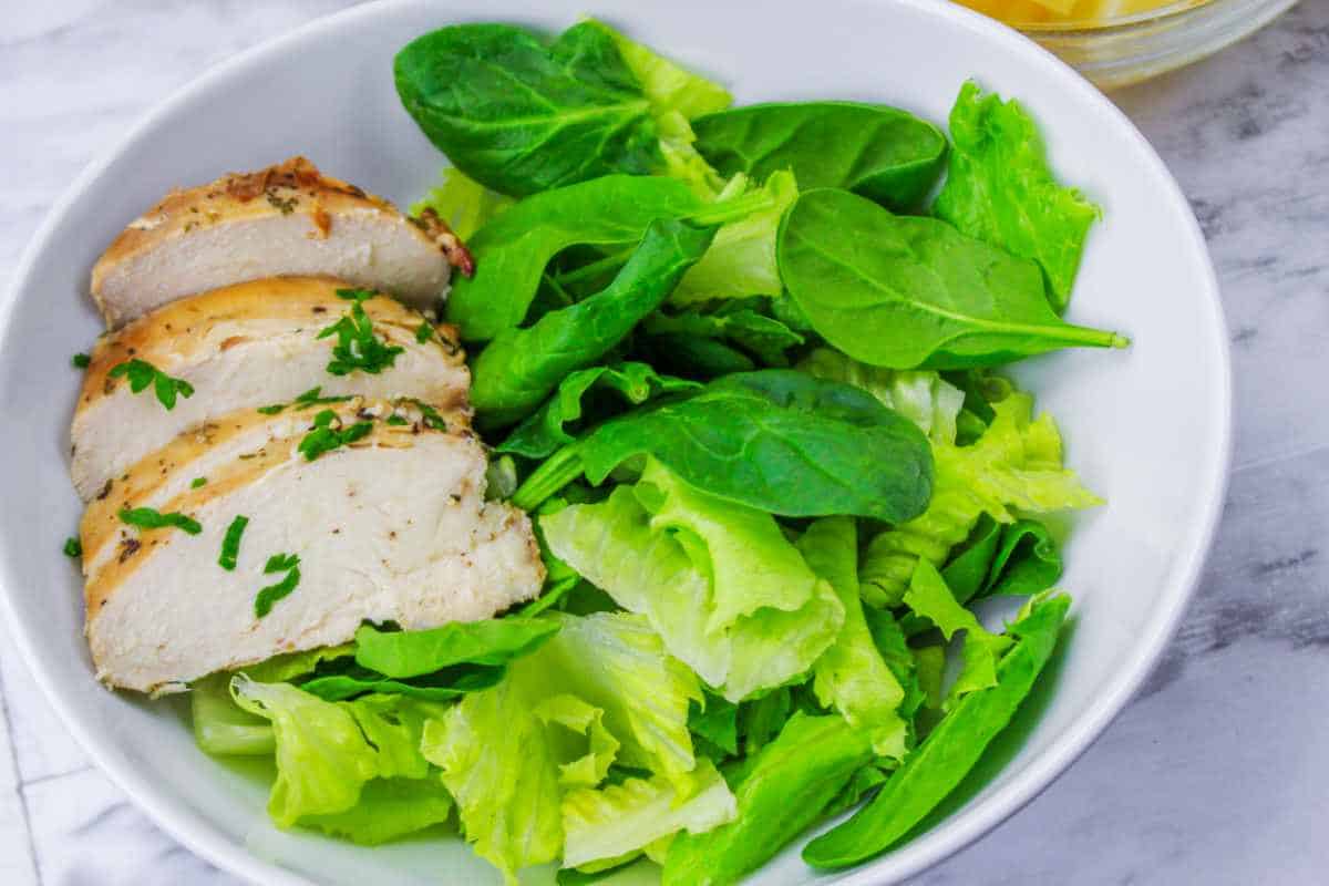 greens and chicken slices in a bowl.