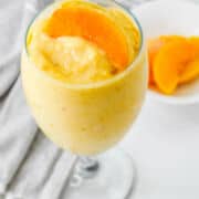 peaches and cream smoothie in a water goblet.
