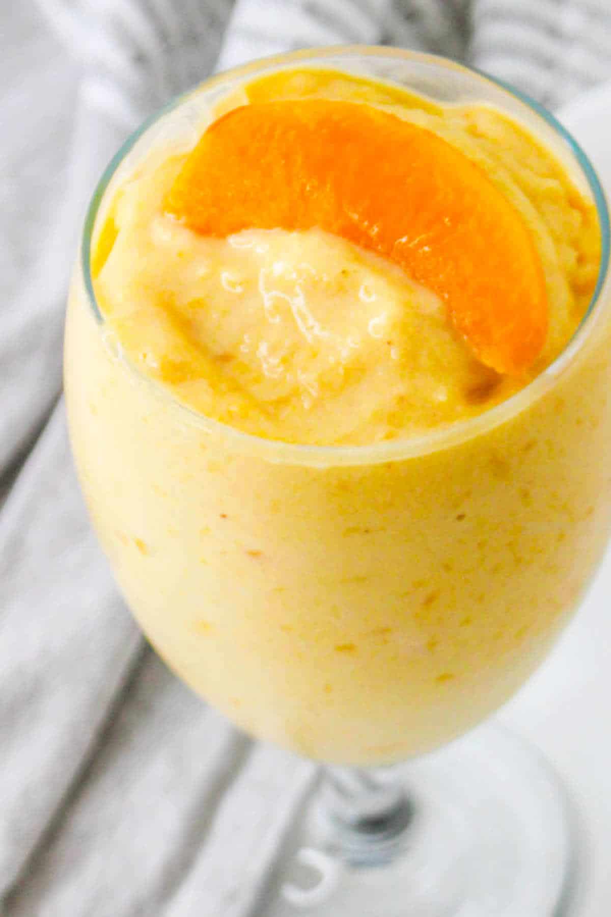 peaches and cream smoothie in a water goblet.