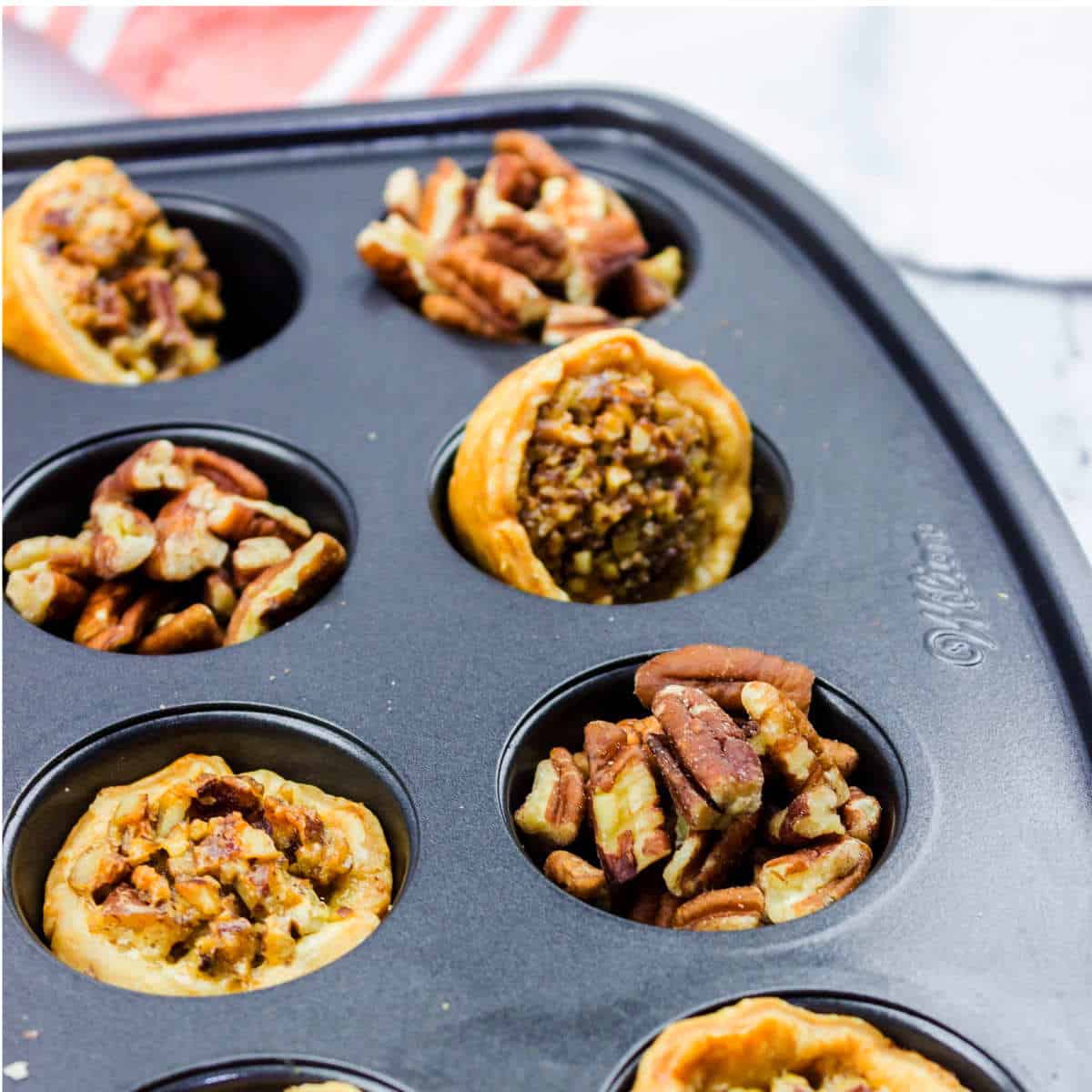 baked pampered chef pecan tassies in a mini muffin pan.