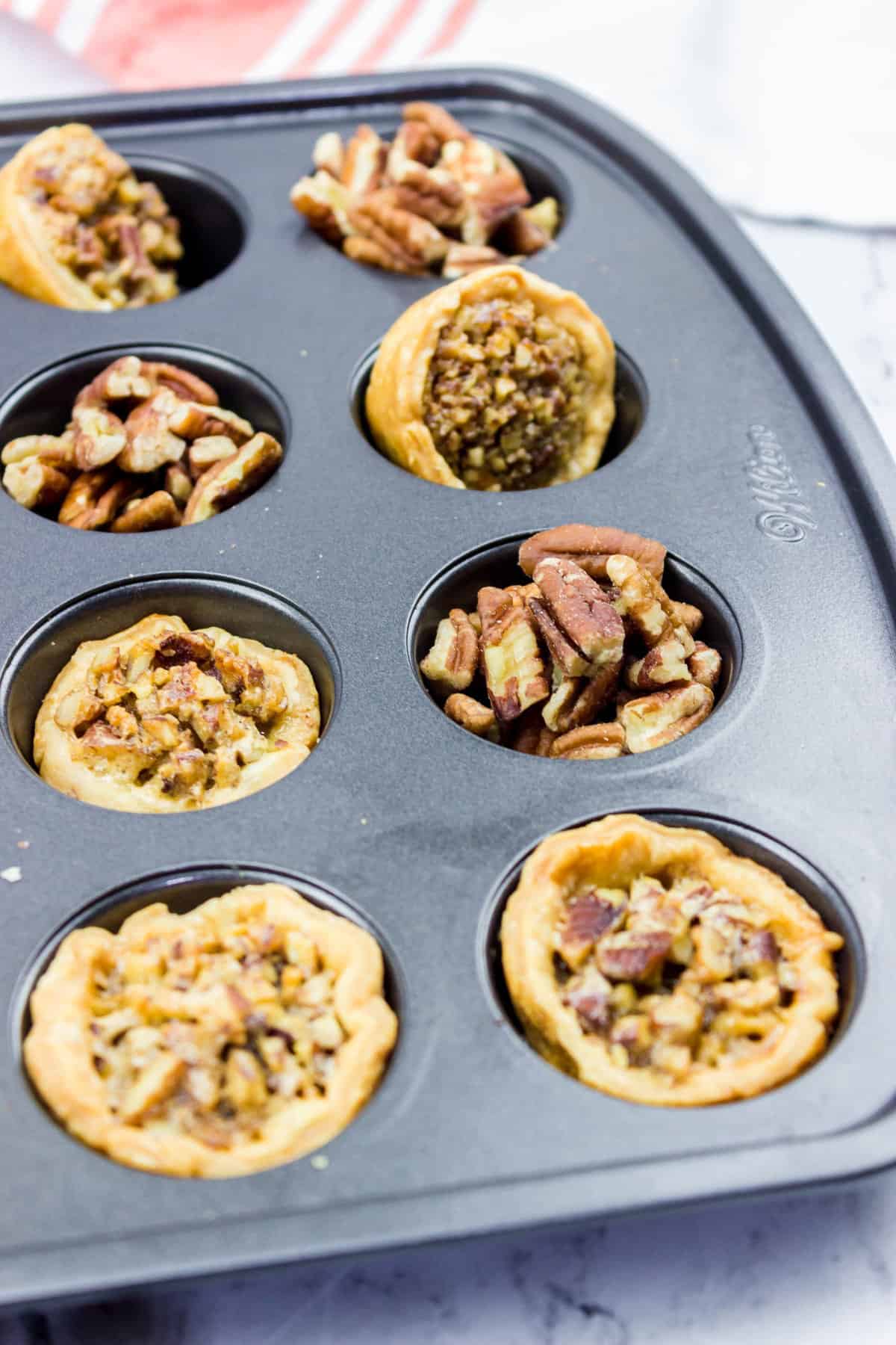 baked pampered chef pecan tassies in a mini muffin pan.