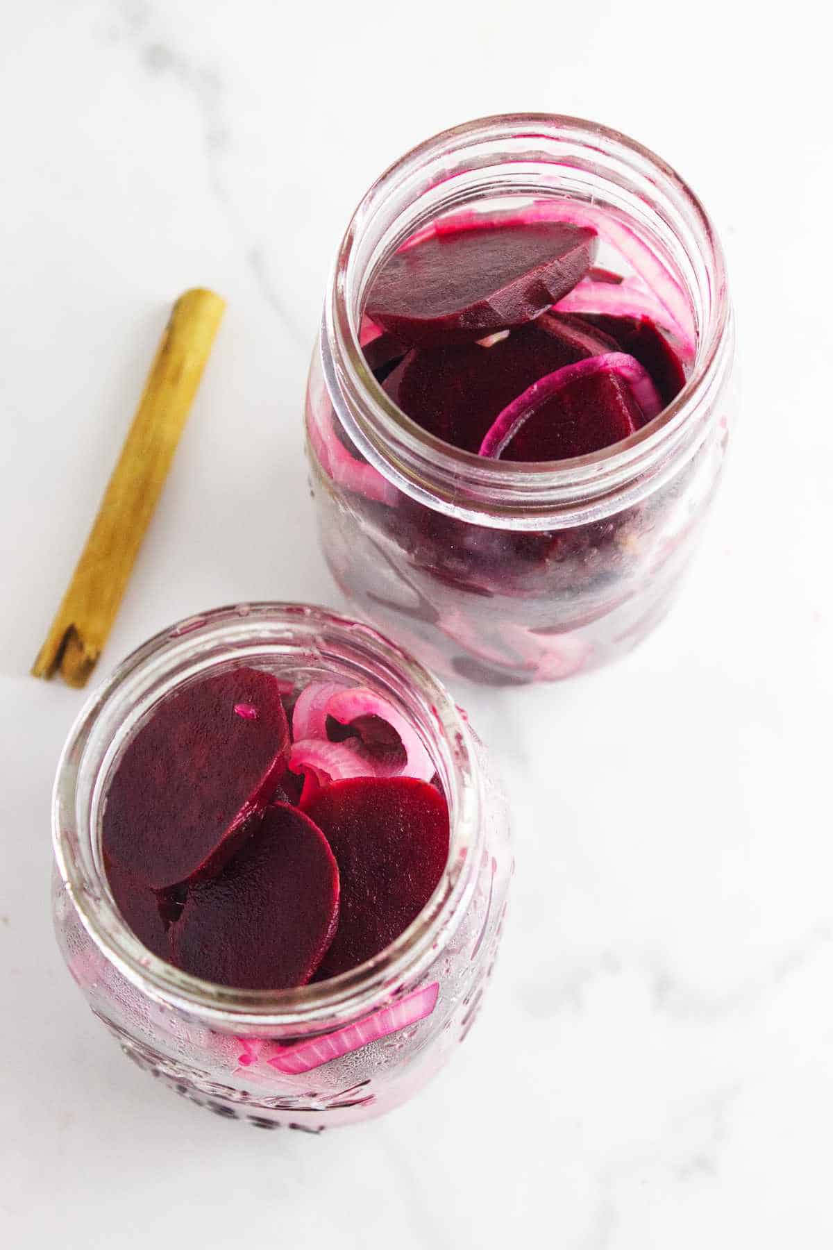 hot beetroot slices added to mason jars.