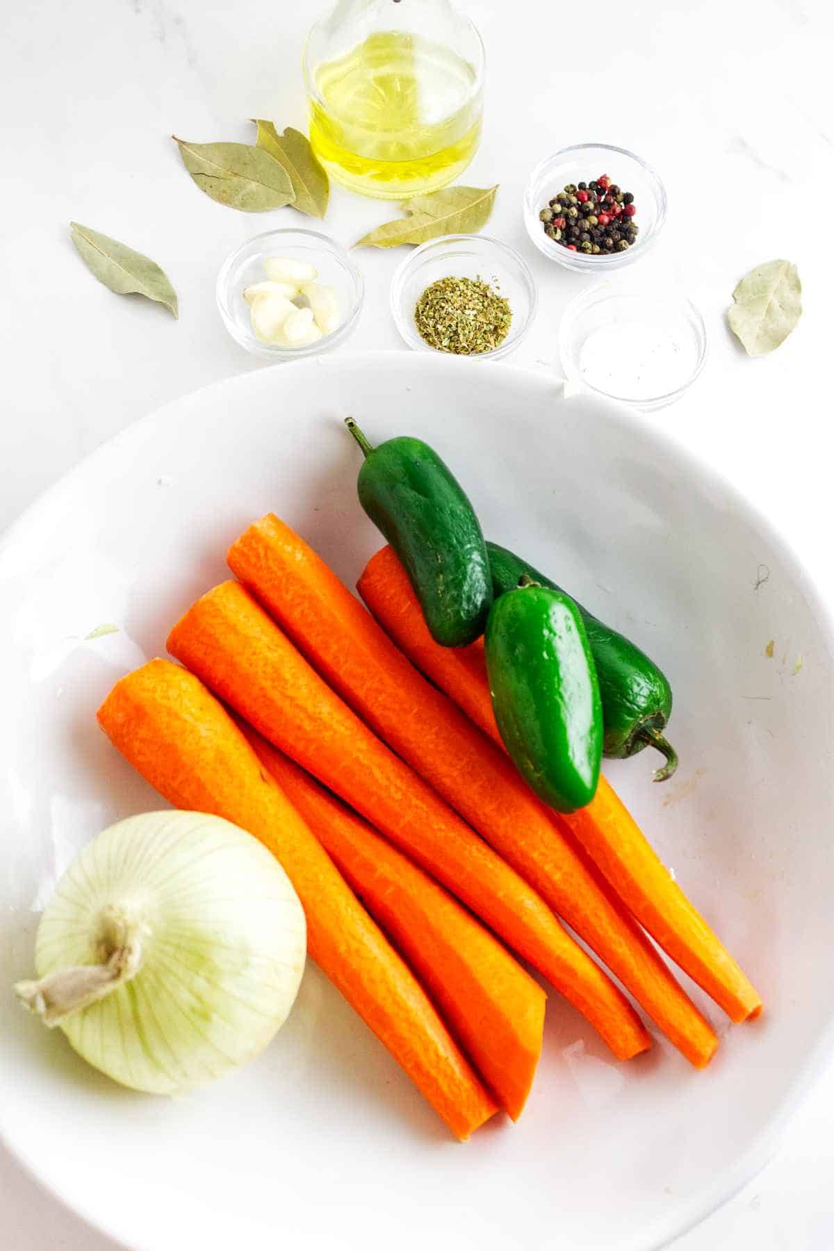 carrots, onion, spics, and jalapeno pepper on a white background.