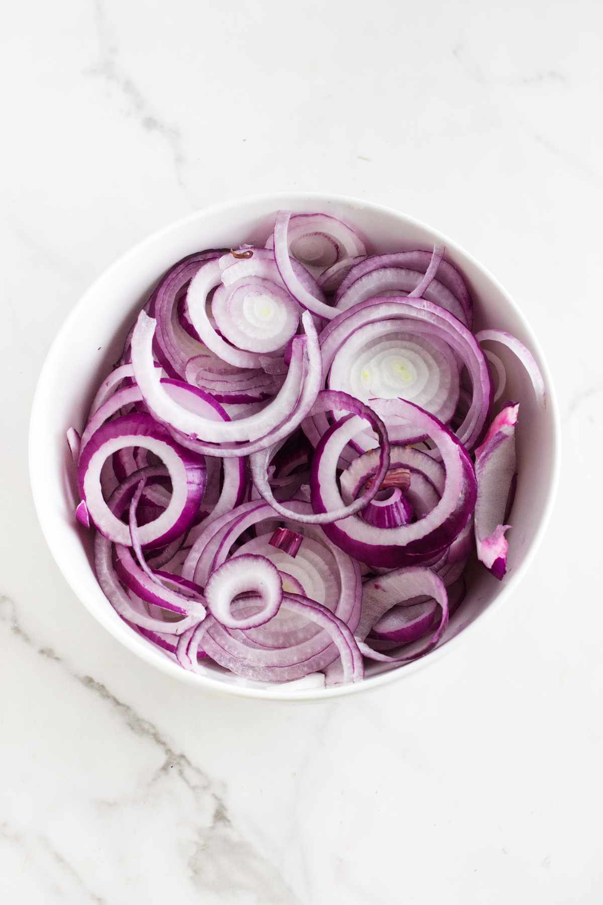 sliced red onions in a bowl.