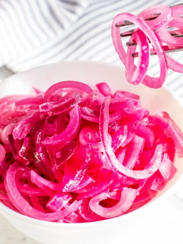 Juicy Mexican pickled red onion marinated in lemon juice on a light background.