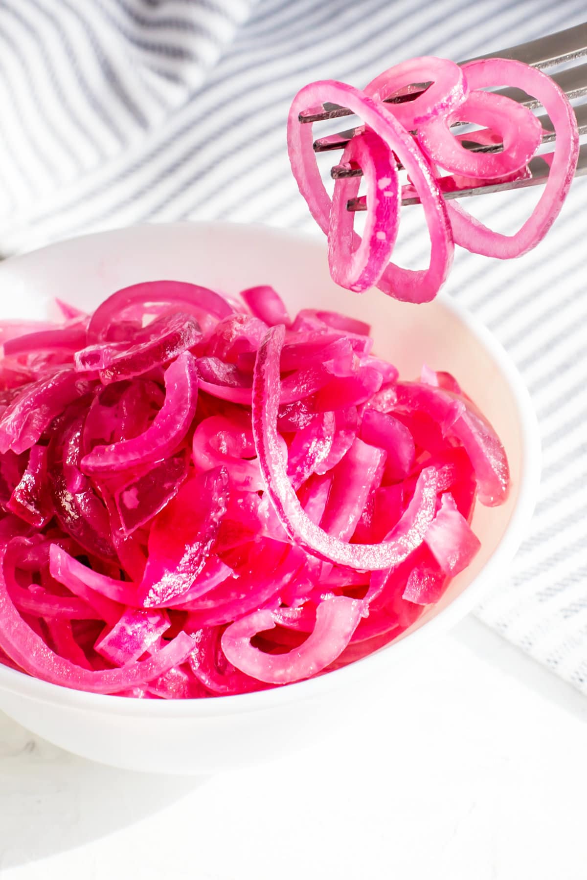 Juicy Mexican pickled red onion marinated in lemon juice on a light background.