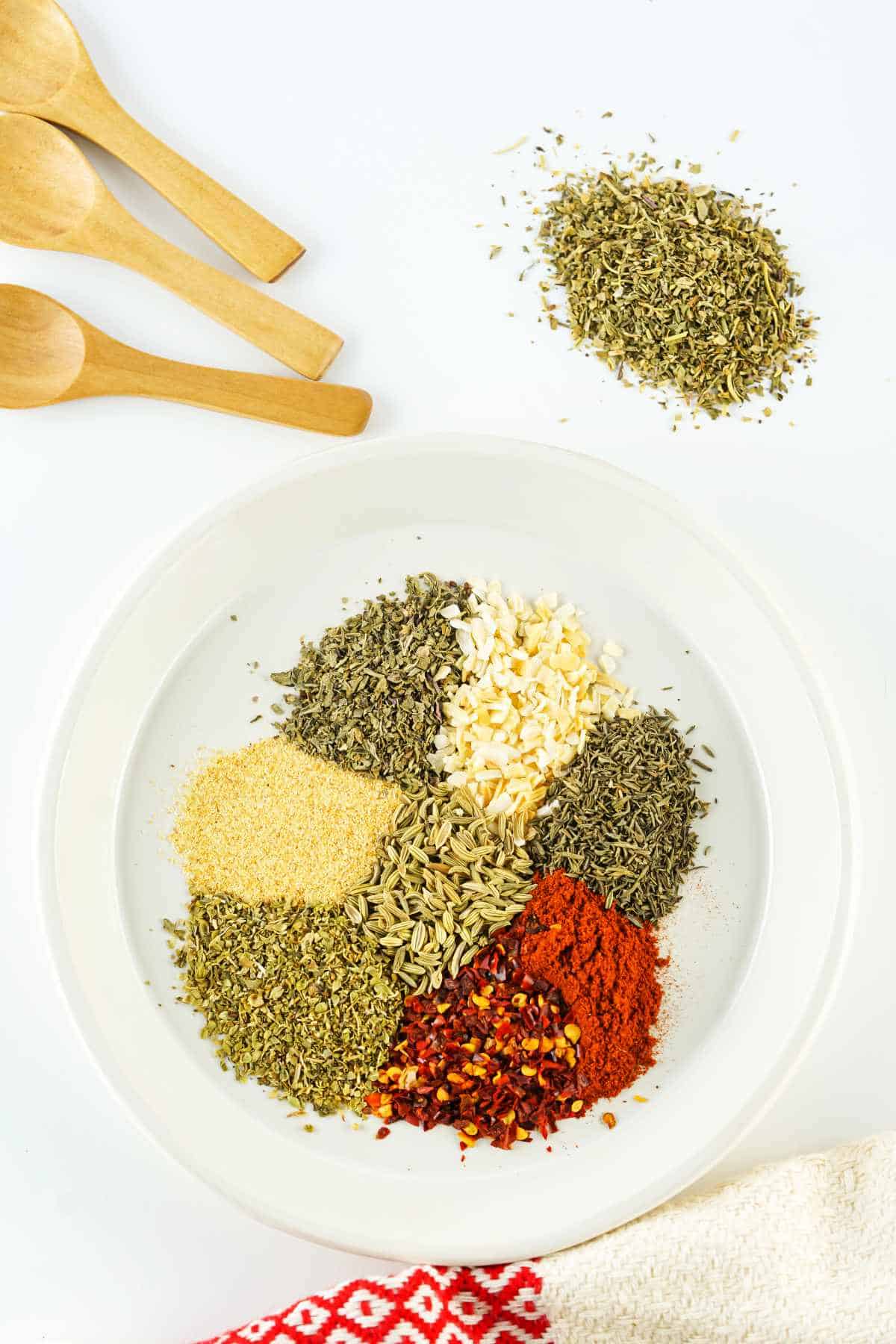 shallow bowl filled with piles of colorful spices and dried herbs.
