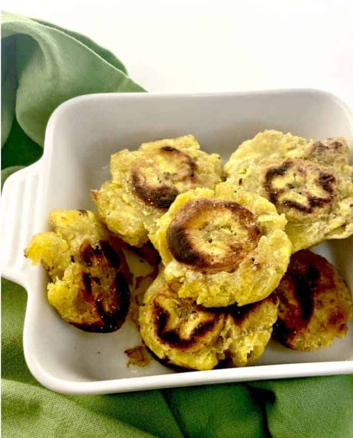 white serving dish of tostones also known as fried green plantains