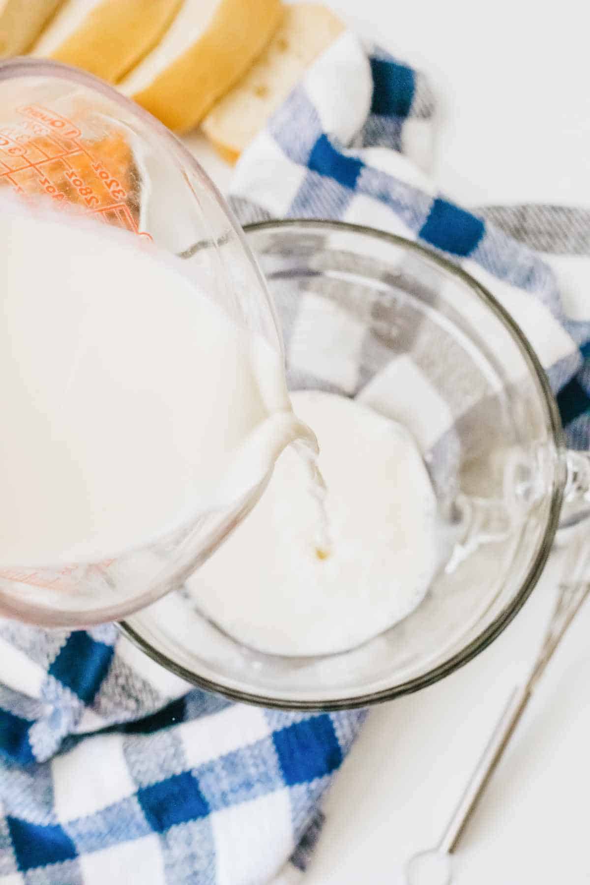 pouring milk or cream into a mixing bowl.