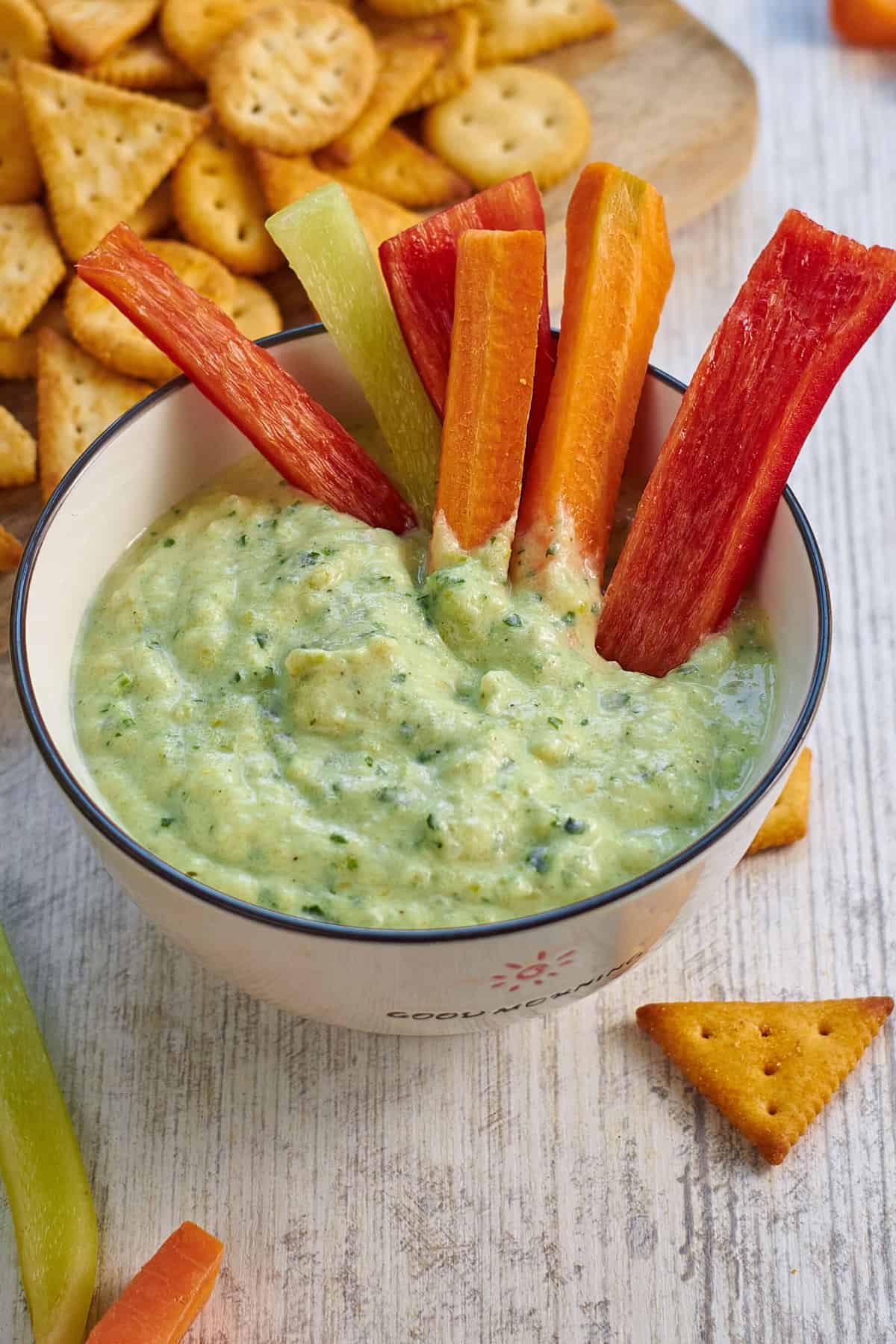 zucchini dip with carrot sticks and crackers.