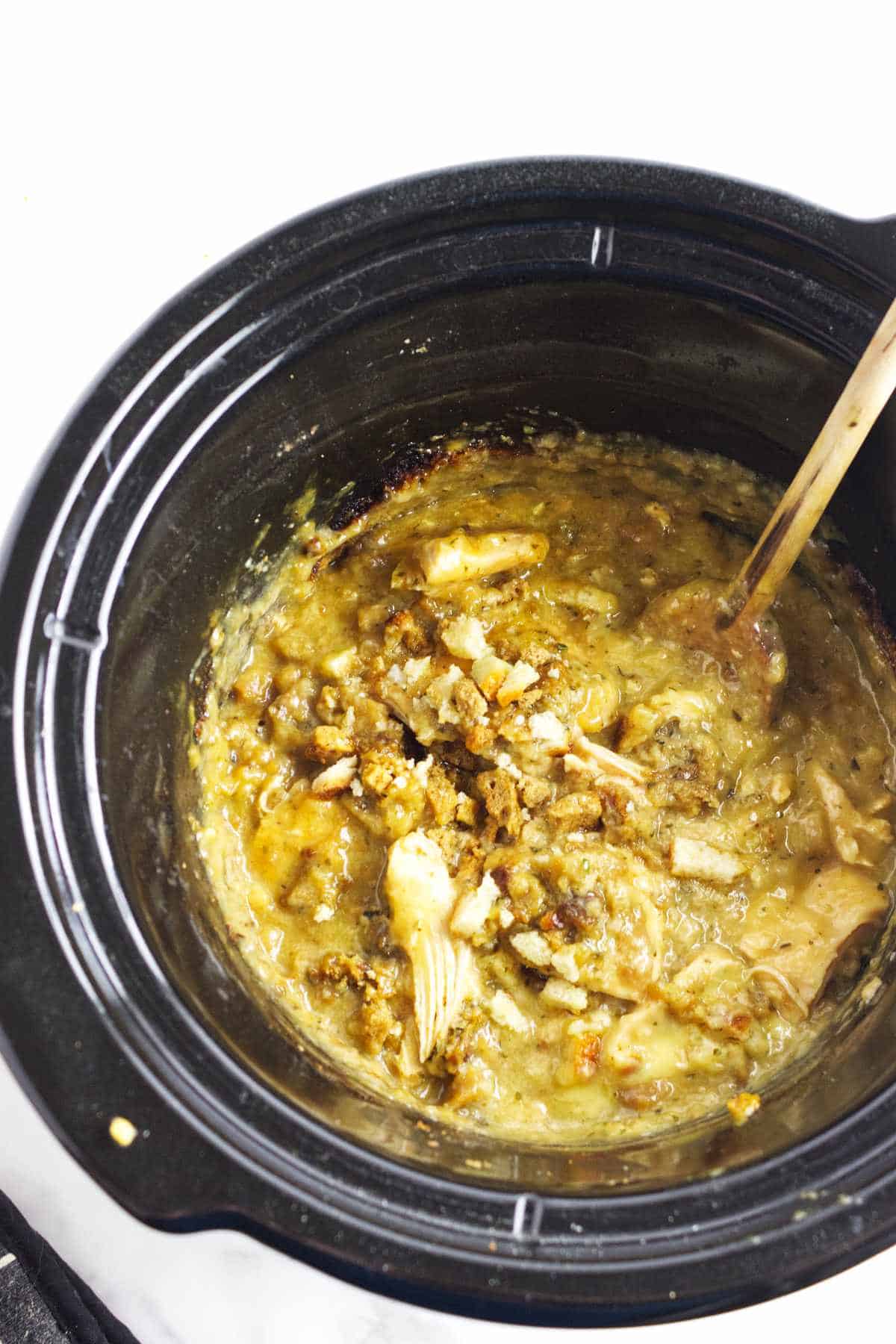 4 ingredient slow cooker chicken with stuffing in a crockpot with a ladle for serving.