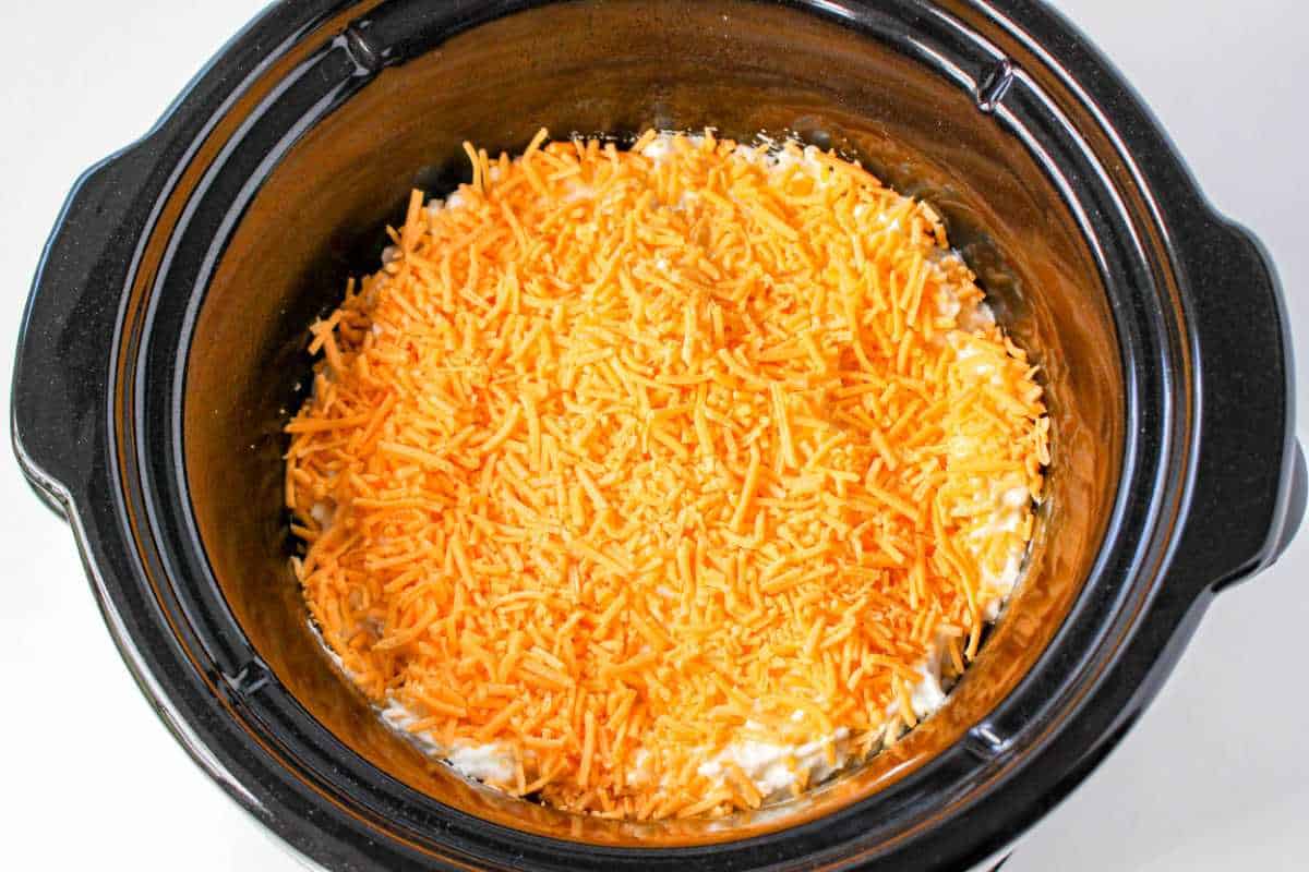 cheddar topped potato mixture in a crockpot.