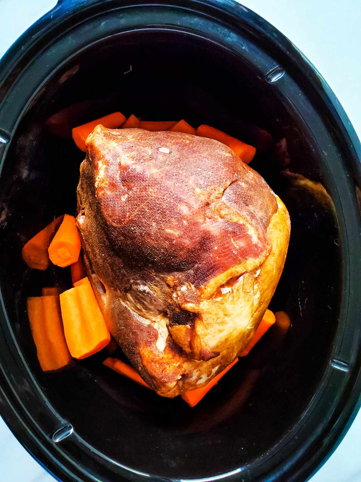slow cooker with gammon and vegetables.