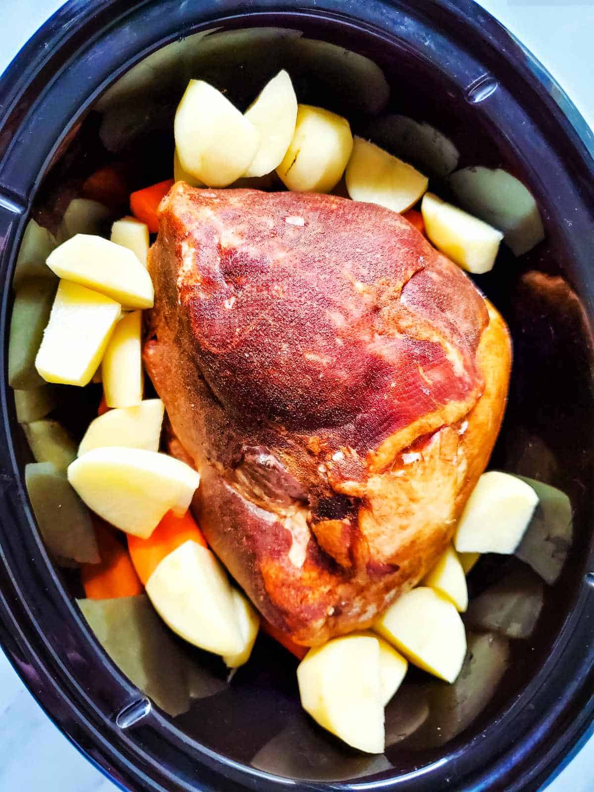 slow cooker with gammon and vegetables.
