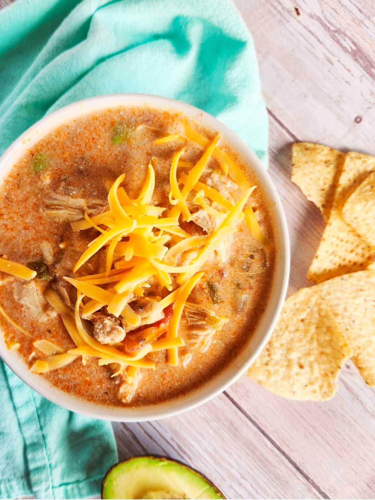 southwest chicken tortilla soup in a bowl with shredded cheese on top.