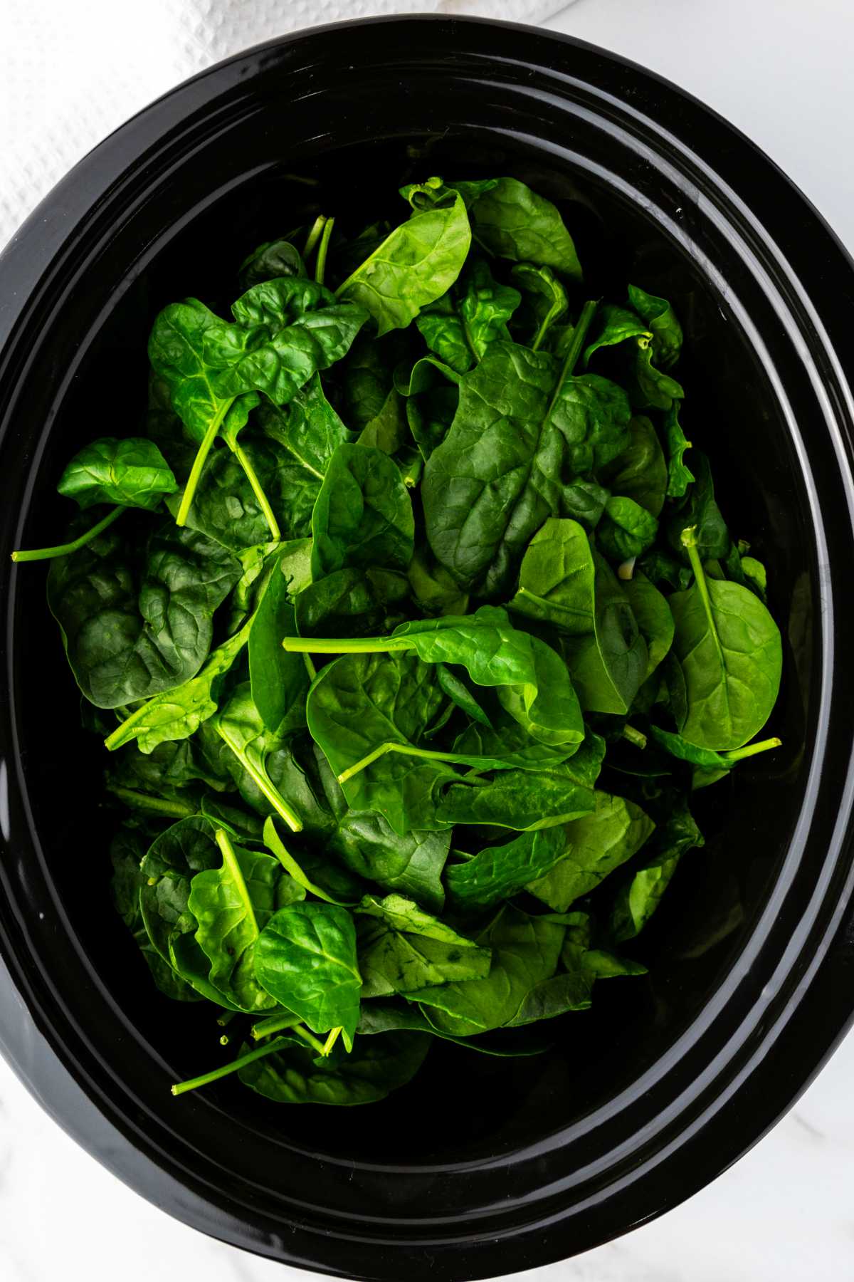 crockpot with fresh greens in it.