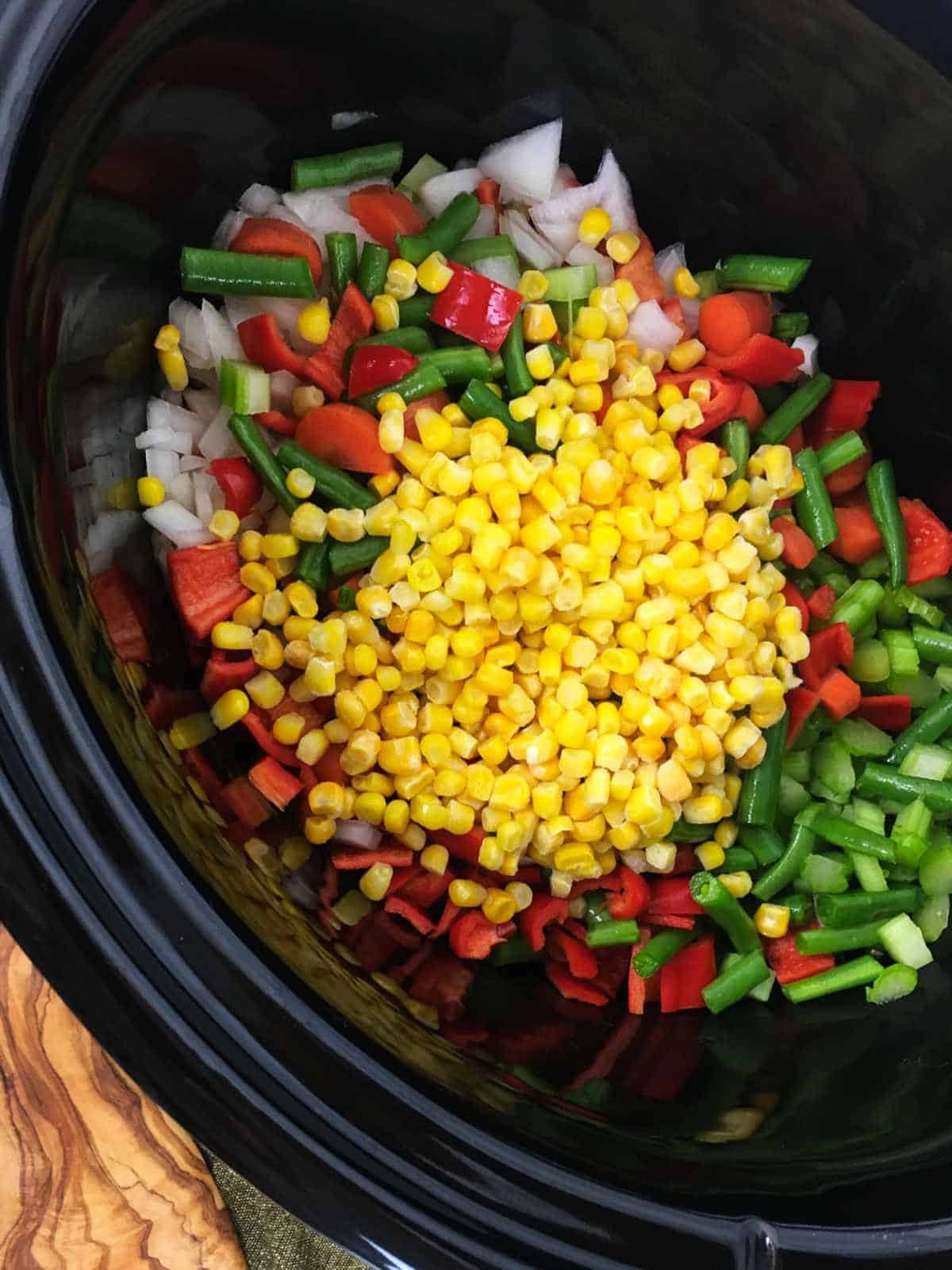 corn and frozen green beans added to a crockpot.