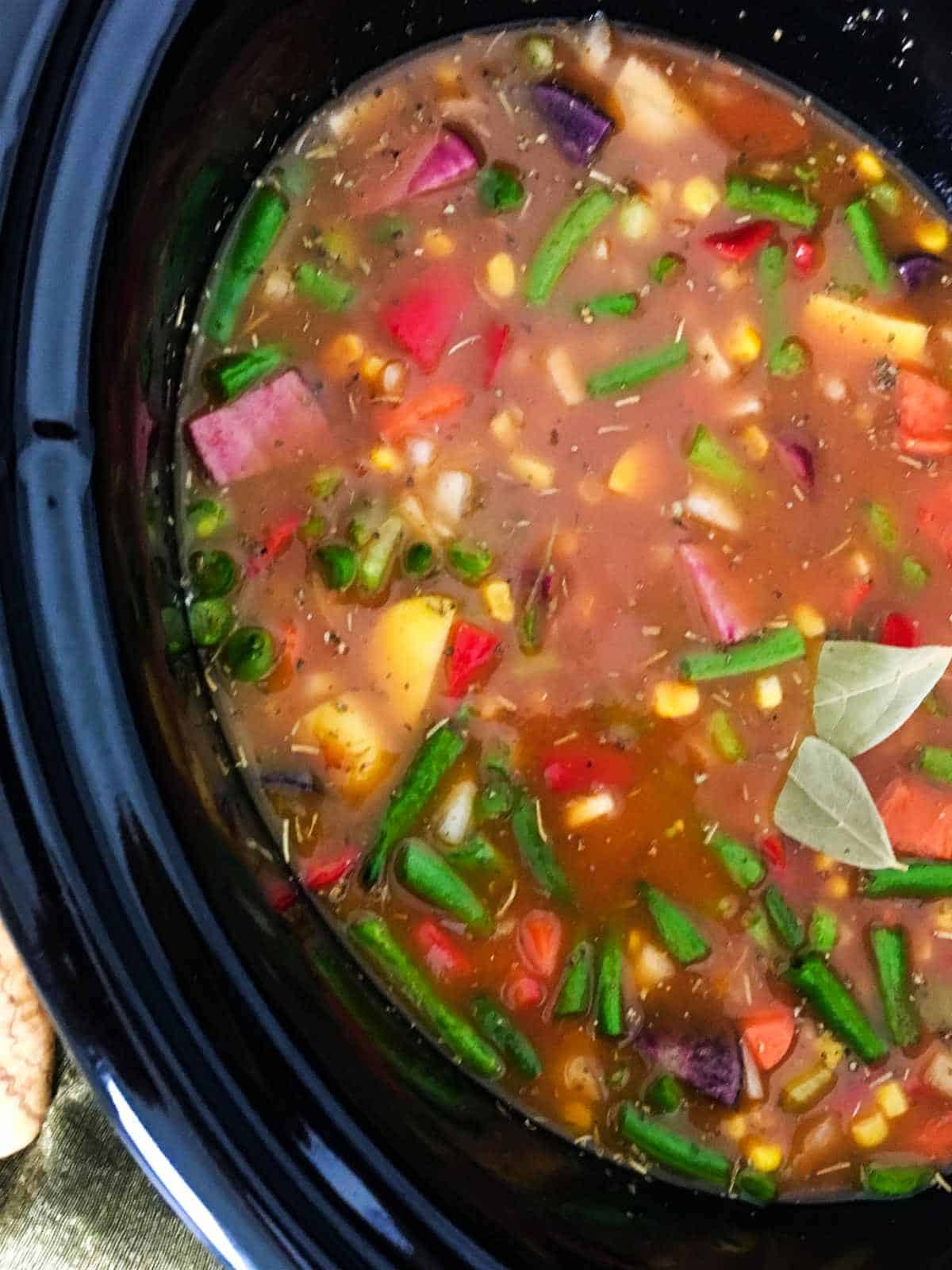 slow cooker with vegetable soup ready to cook.