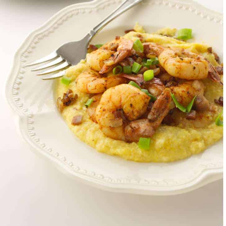 shrimp on yellow grits in a white bowl