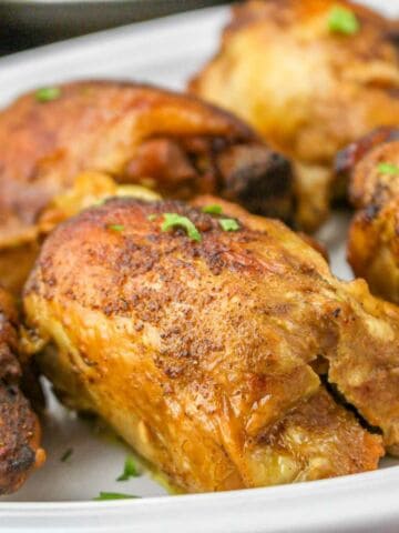 slow cooked caribbean chicken thighs on a platter.